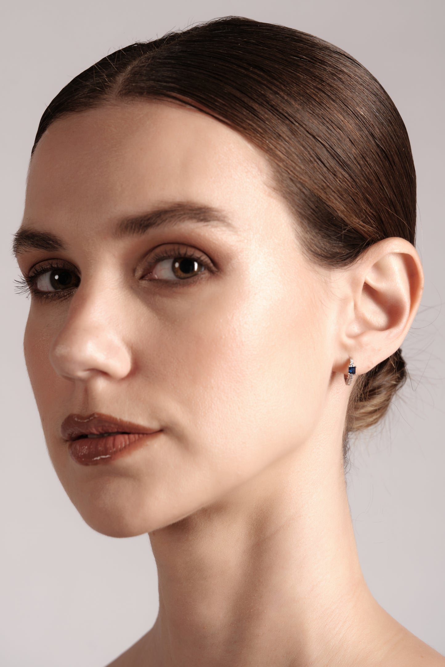 Model wearing Petite Saphire small hoop earrings — minimalist blue CZ drop with pavé hoop
