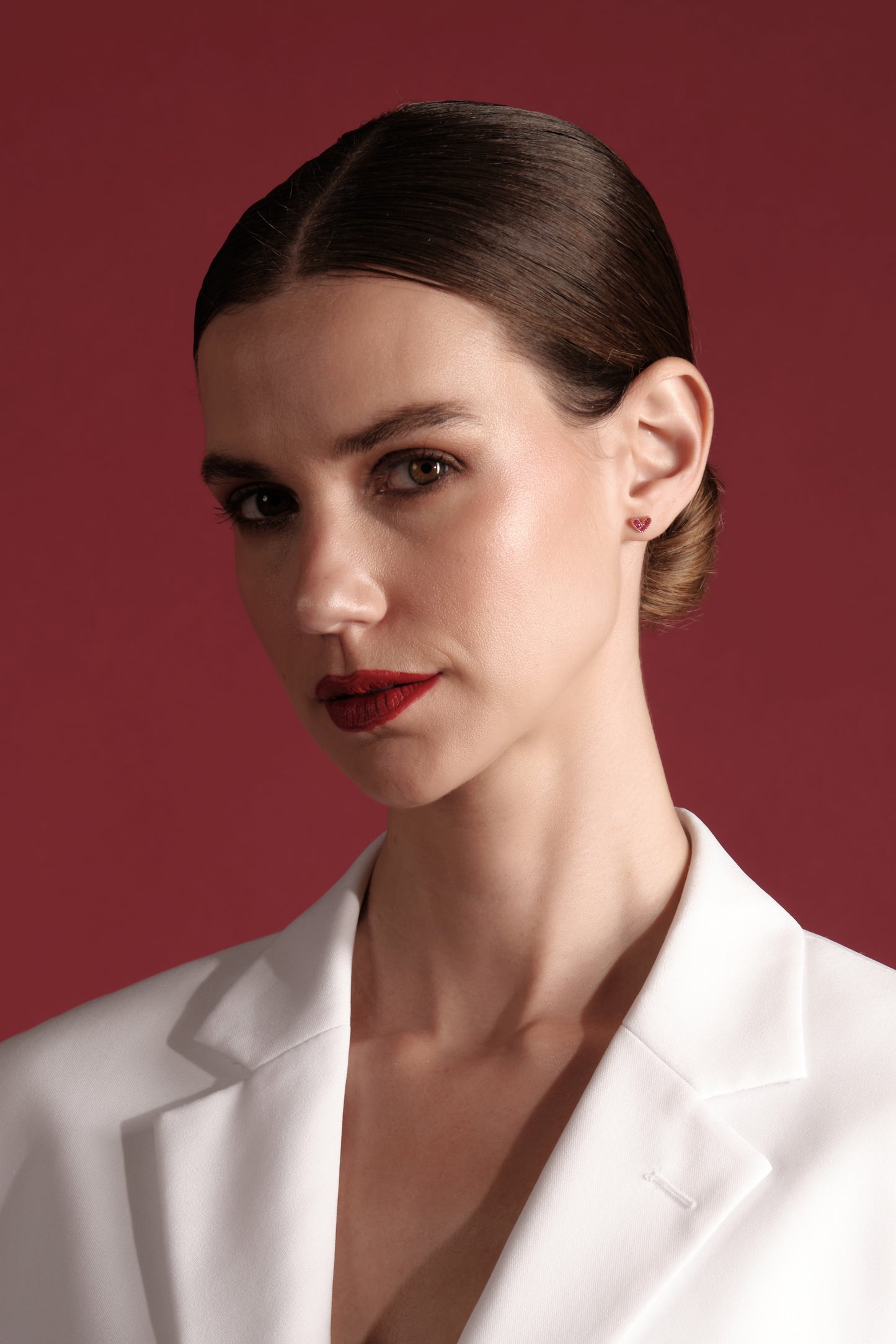 Model wearing rose Amour Studs — 925 sterling silver rose‑gold plated heart stud earrings with pink cubic zirconia