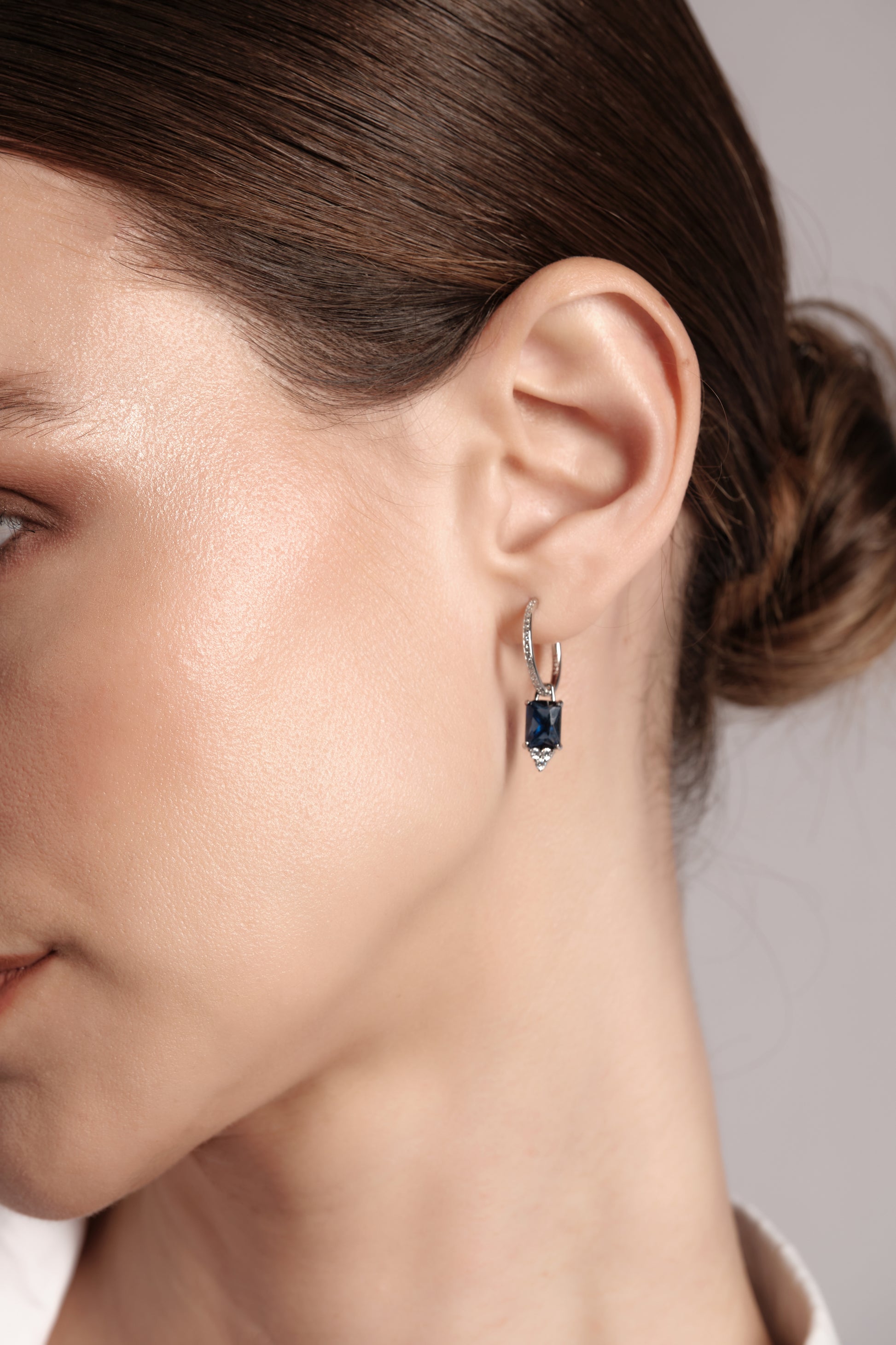 Close‑up of Sonnet of Blue 925 sterling silver earrings — rectangular blue drop stone with pavé hoop