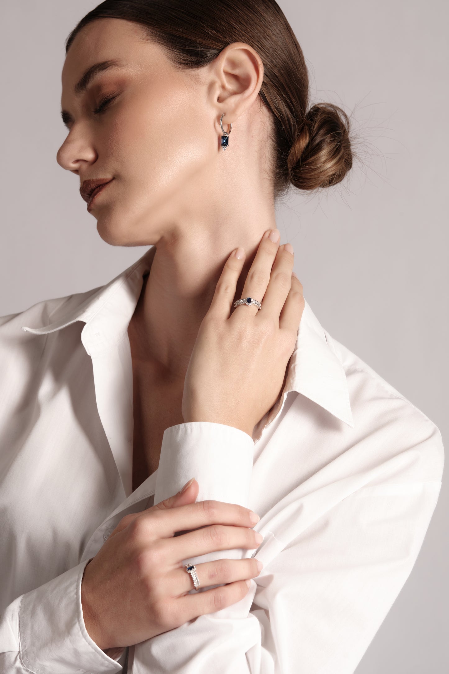 Model wearing Sonnet of Blue earrings — elegant blue drop and pavé hoop styling